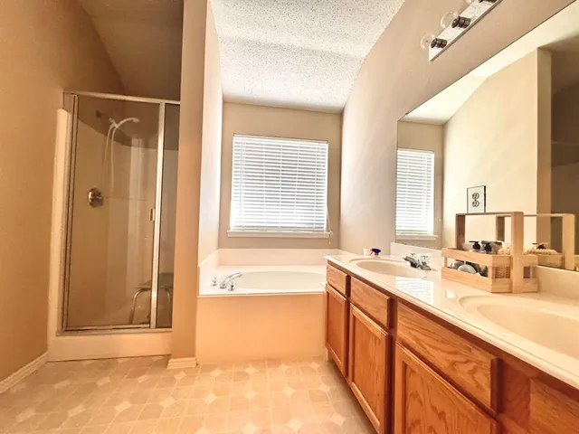 a spacious bathroom with a tub sink and mirror