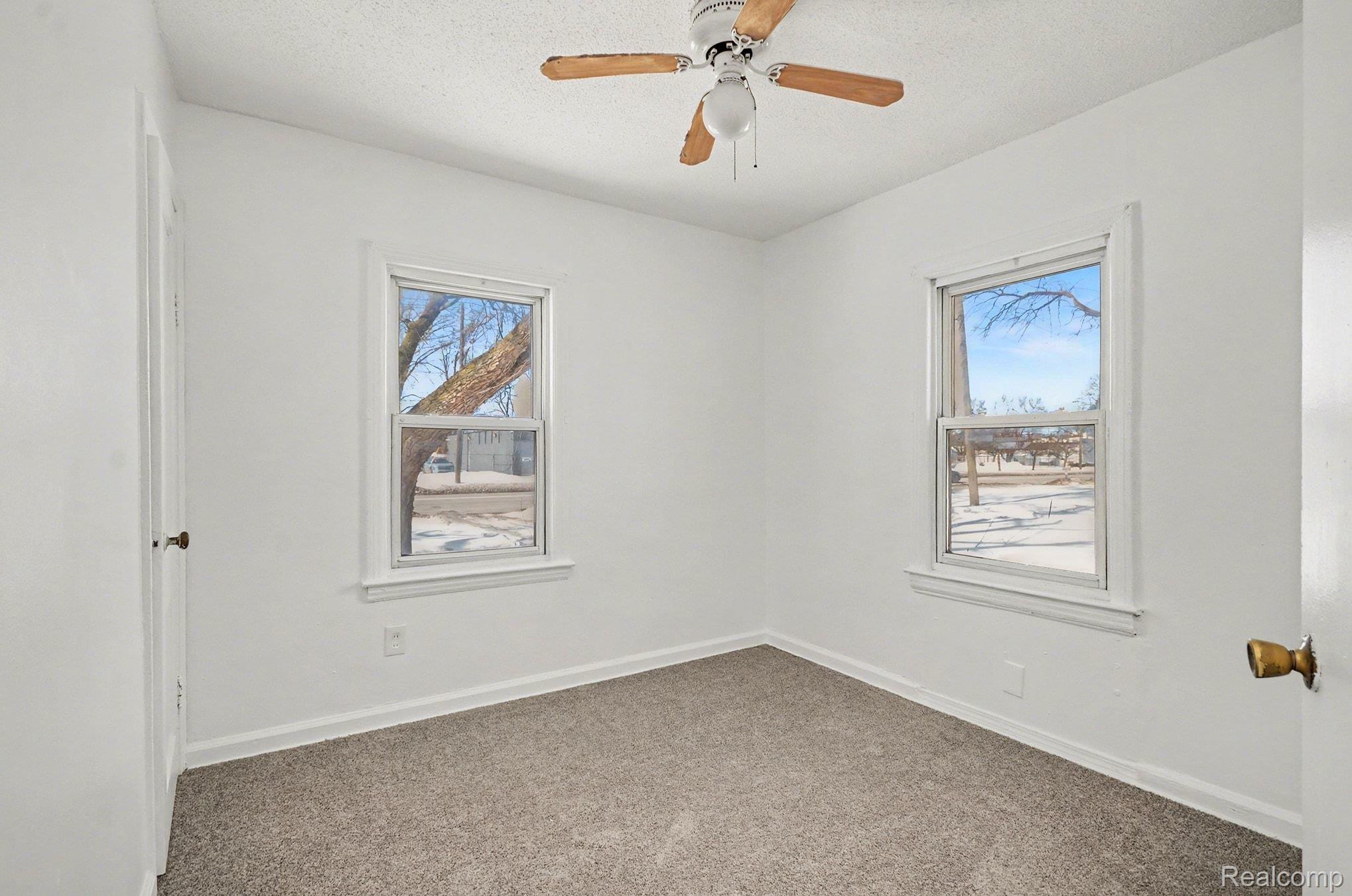 23346 Hoover Road Warren, MI 48089 - Photo 7 of 15 Spare room with carpet, a textured ceiling, and a ceiling fan