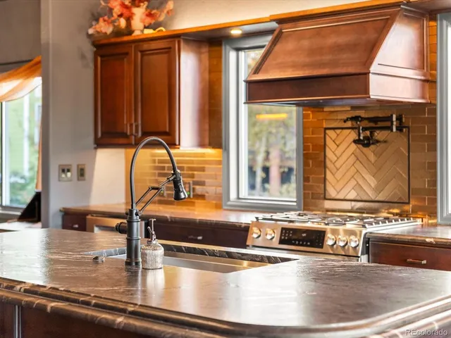a view of a kitchen with kitchen island a large window and a sink