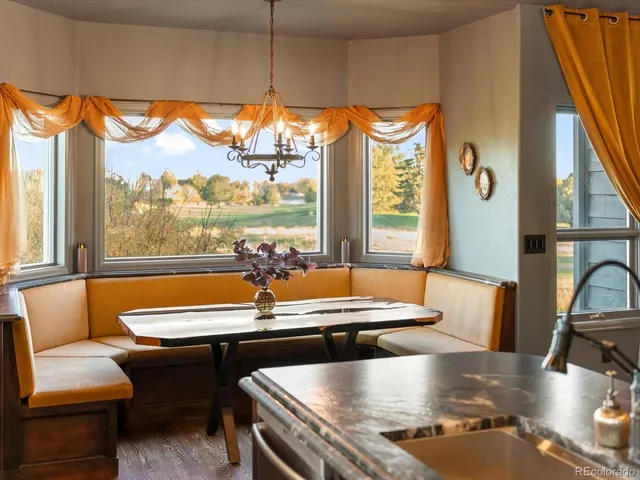 a dining room with furniture and a large window