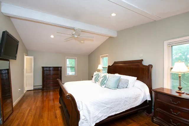 a bedroom with a bed and a flat tv screen on dresser