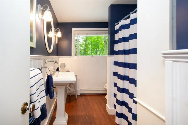 a bathroom with a sink a toilet a mirror and shower