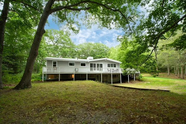 a view of a big house with a big yard and large trees