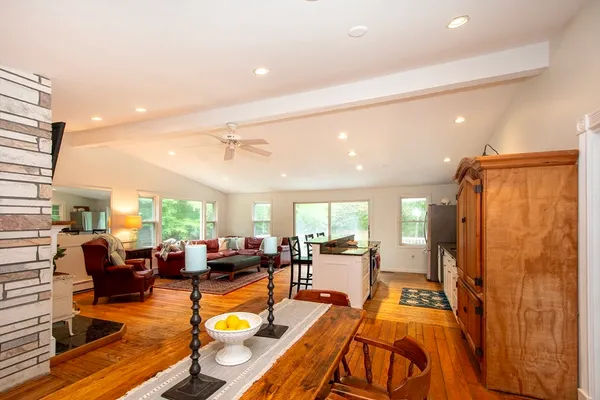 a living room with furniture kitchen view and a large window
