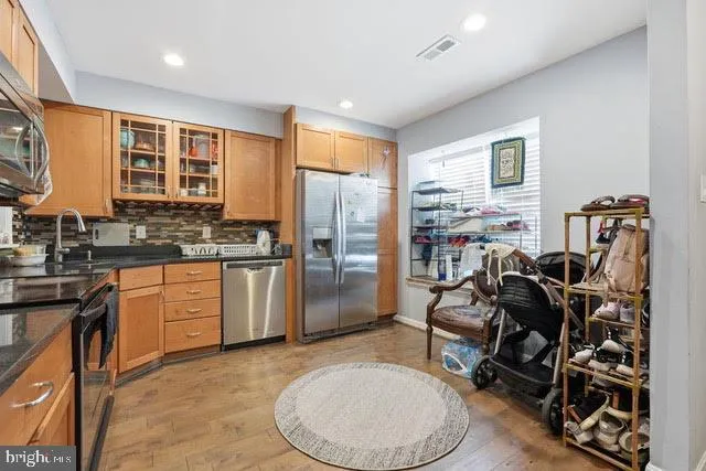 a kitchen with stainless steel appliances granite countertop a stove a sink and a refrigerator