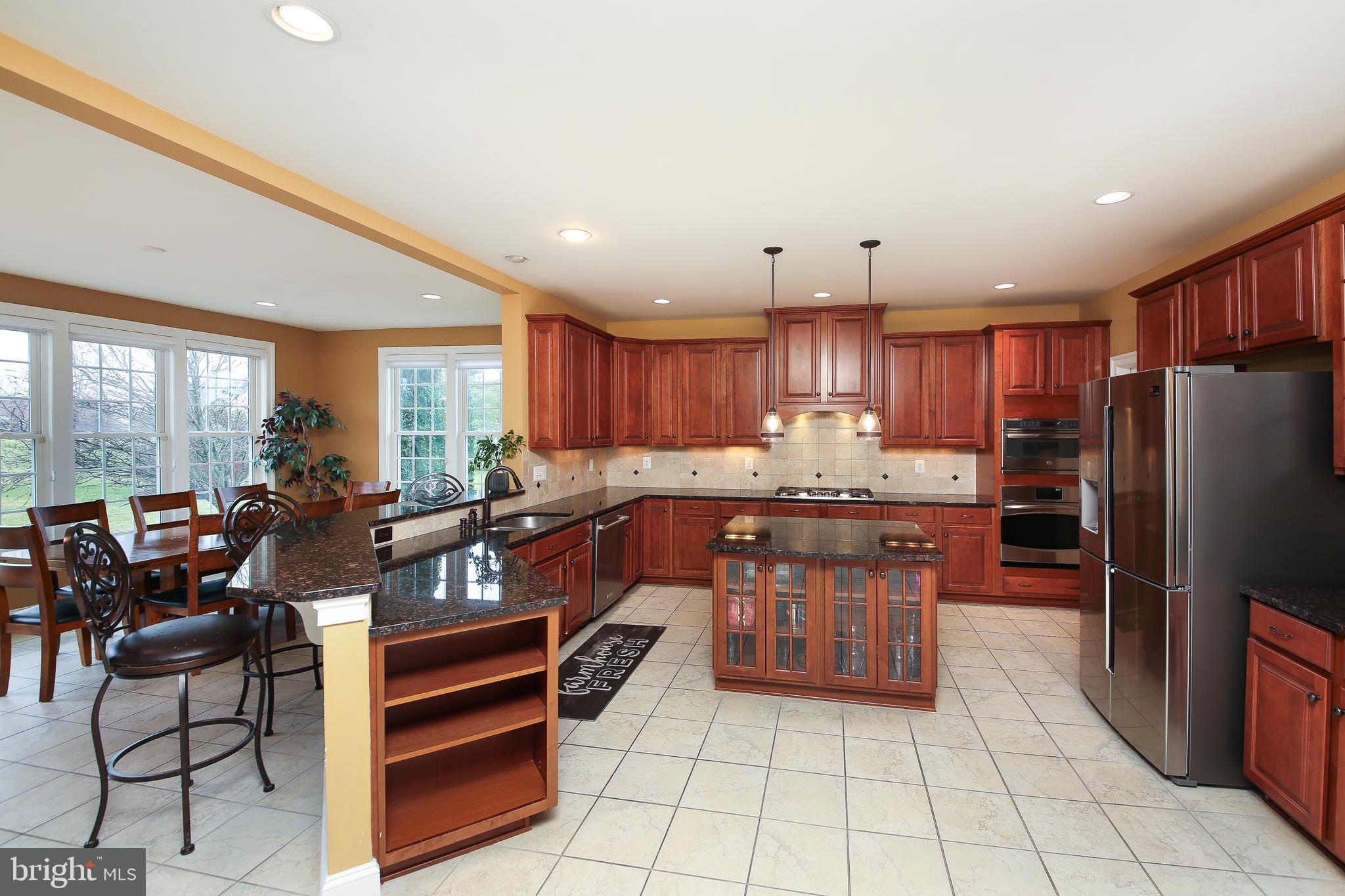 342 Alexander Drive Telford, PA 18969 - Photo 6 of 31 a kitchen with stainless steel appliances kitchen island granite countertop a refrigerator a stove a sink and a dining table with wooden floor