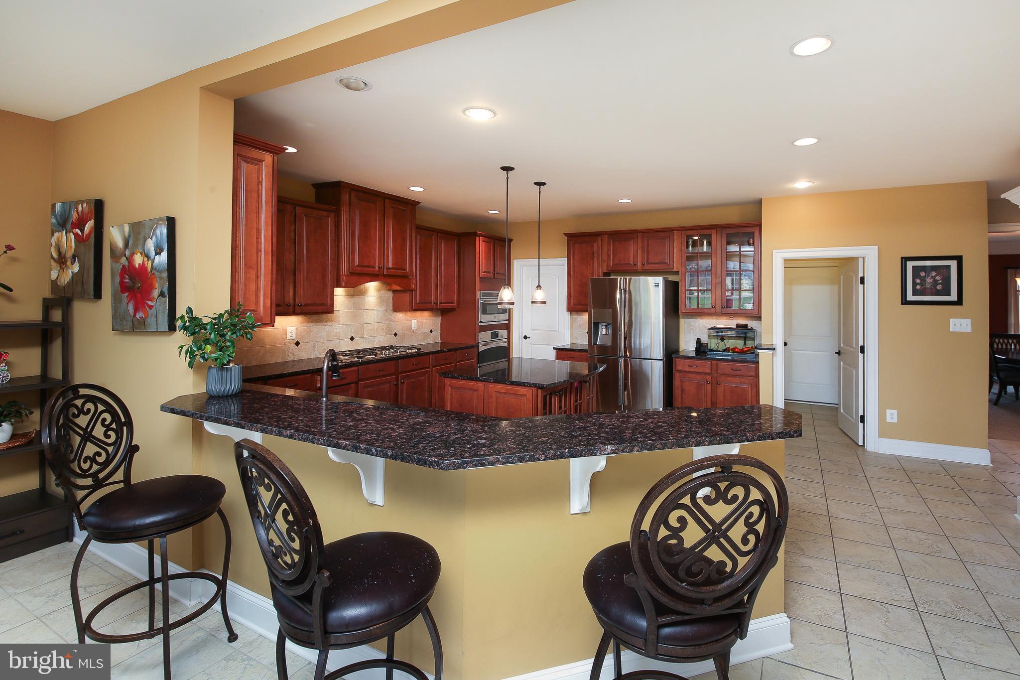 342 Alexander Drive Telford, PA 18969 - Photo 7 of 31 a kitchen with stainless steel appliances granite countertop a stove a sink a dining table and chairs