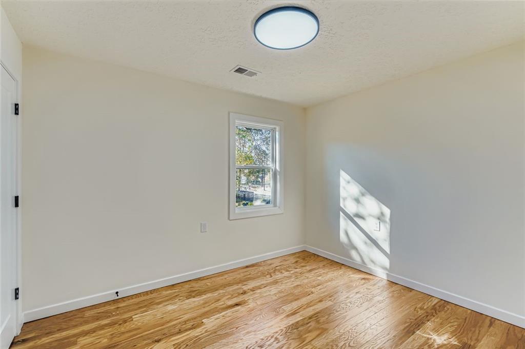 194 Dearborn Street Southeast Atlanta, GA 30317 - Photo 16 of 25 an empty room with wooden floor and windows