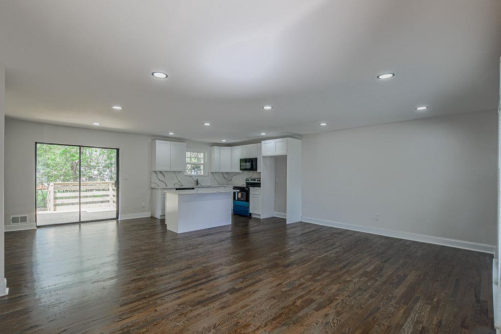 2248 Willoby Court Morrow, GA 30260 - Photo 2 of 31 an open kitchen with white cabinets and wooden floor