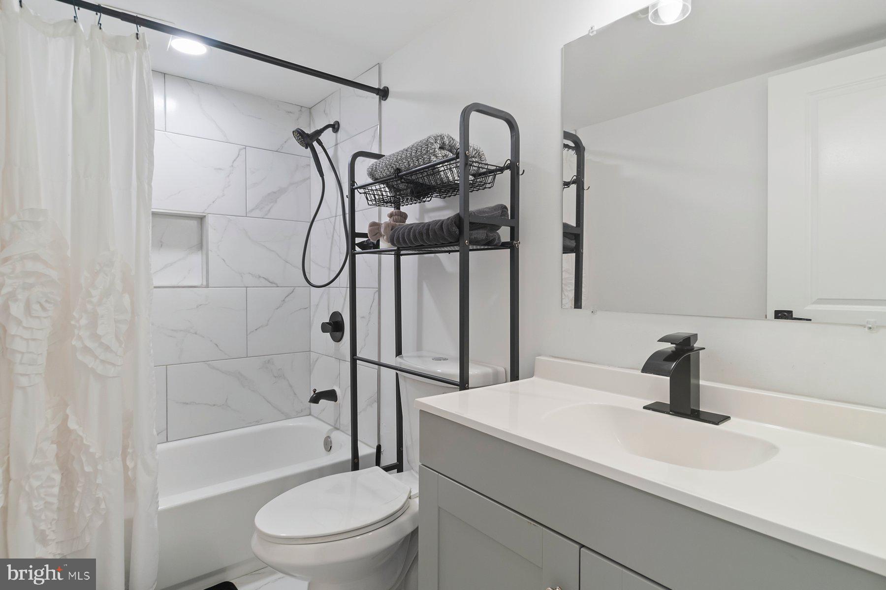 1221 East Oliver Street Baltimore, MD 21202 - Photo 12 of 26 a bathroom with a shower a sink and a toilet