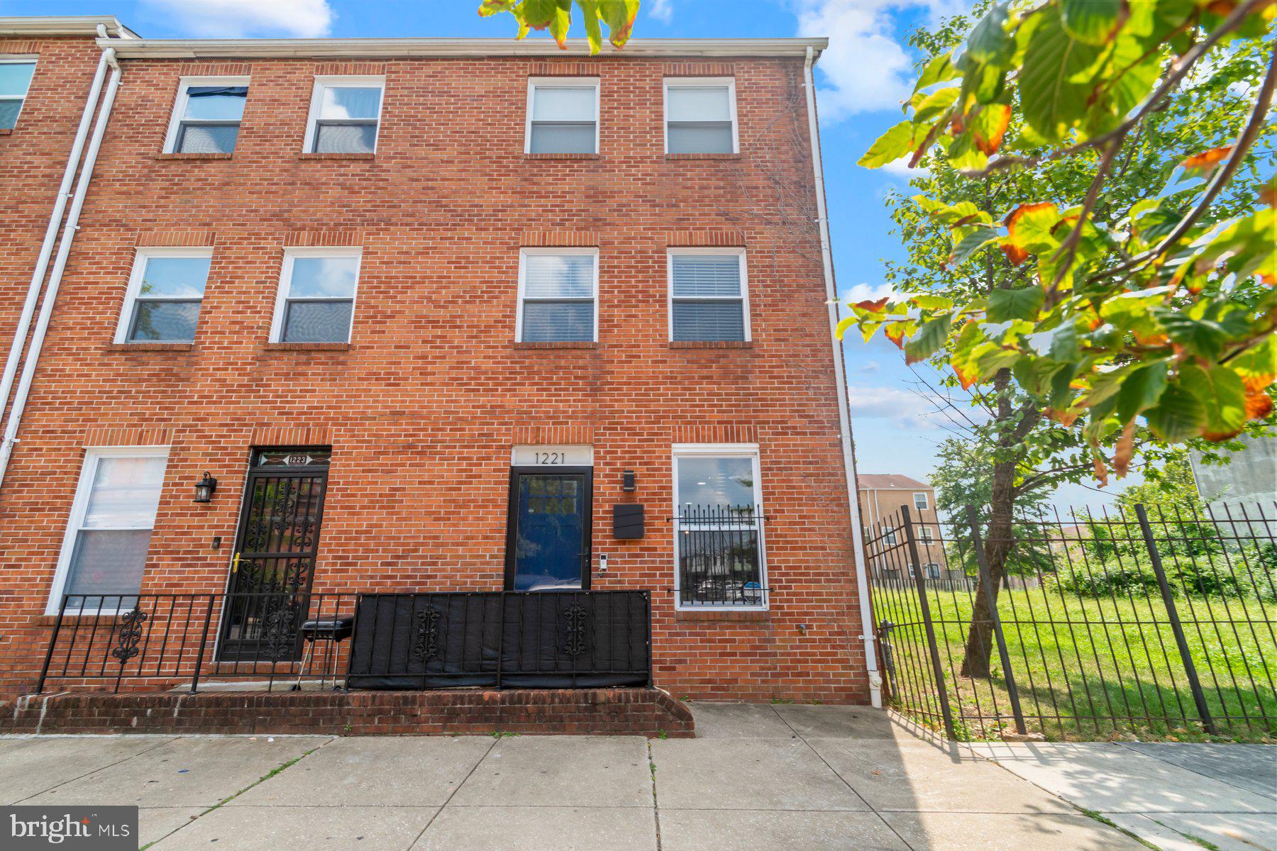 1221 East Oliver Street Baltimore, MD 21202 - Photo 3 of 26 a brick building with a tree in front of it
