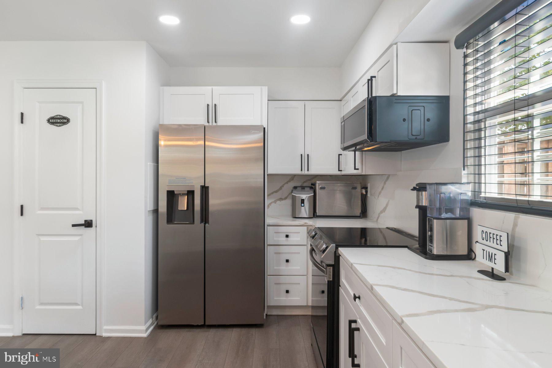 1221 East Oliver Street Baltimore, MD 21202 - Photo 7 of 26 a kitchen with stainless steel appliances a refrigerator sink and cabinets
