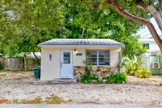 a front view of house with a yard and potted plants