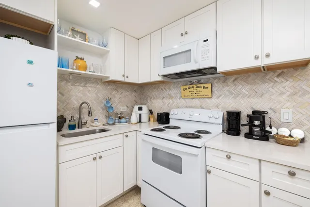 a kitchen with cabinets appliances a sink and a counter top