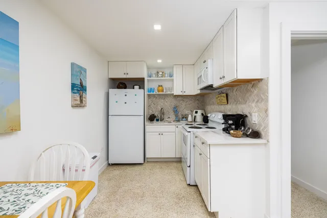 a kitchen with stainless steel appliances granite countertop a refrigerator sink stove and white cabinets