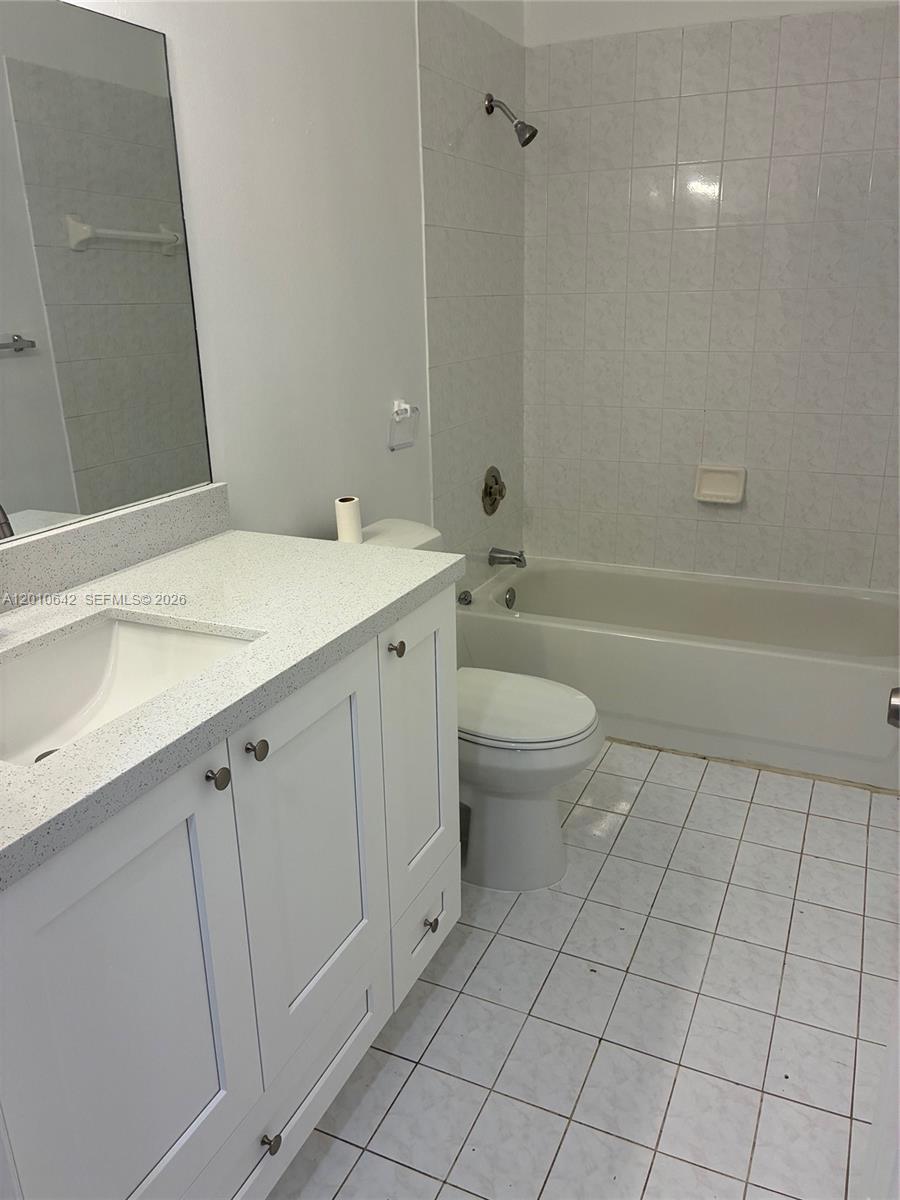 7640 Southwest 153rd Court, Unit 207 Miami, FL 33193 - Photo 3 of 8 a spacious bathroom with a granite countertop sink a toilet and bathtub