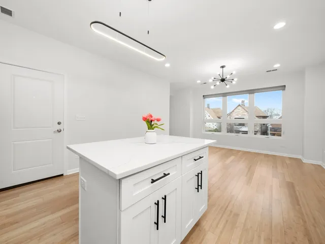 a kitchen with kitchen island white cabinets and refrigerator