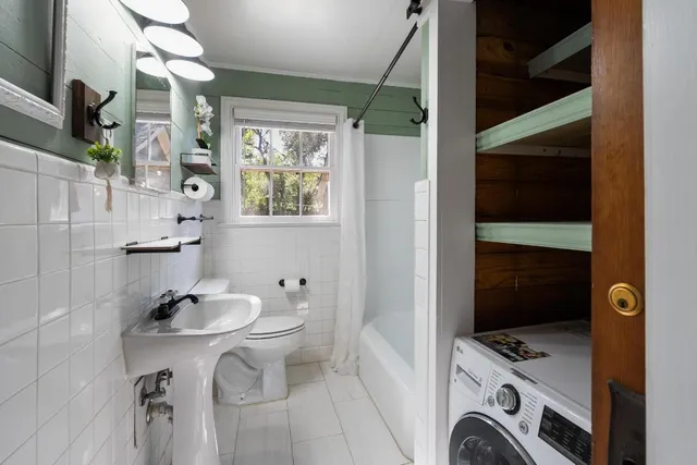 an empty room with chandelier fan and windows