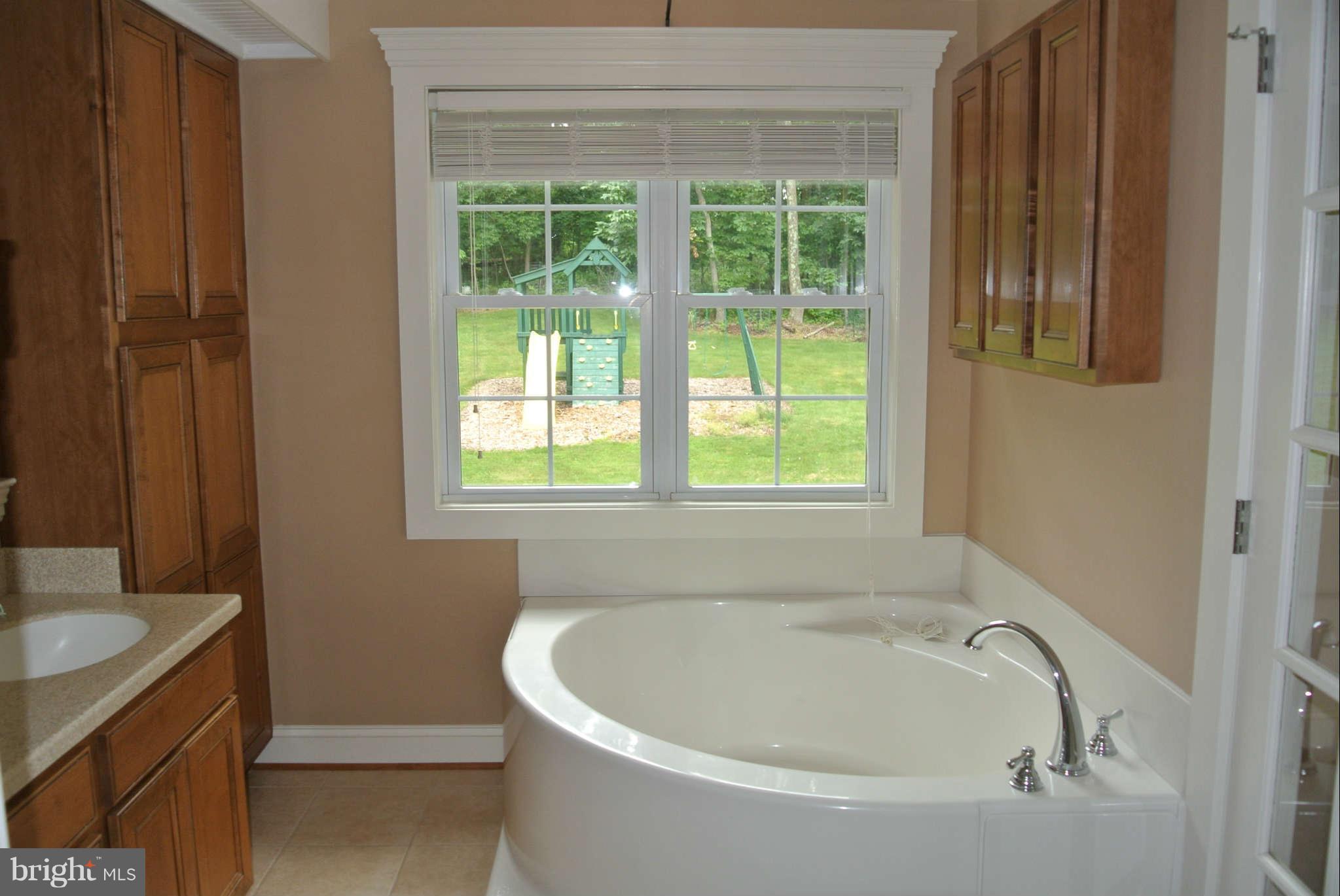 173 Cotton Ridge Road Winchester, VA 22603 - Photo 23 of 28 a white bath tub sitting in a bathroom next to a window