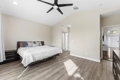 a spacious bedroom with a bed and wooden floor