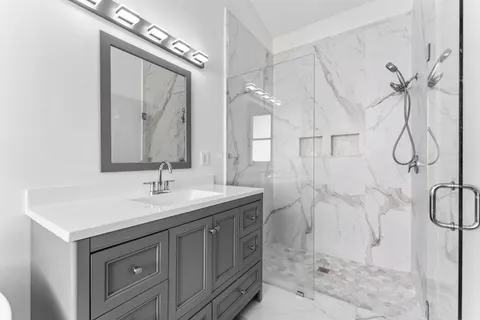 a bathroom with a granite countertop sink a toilet and a mirror