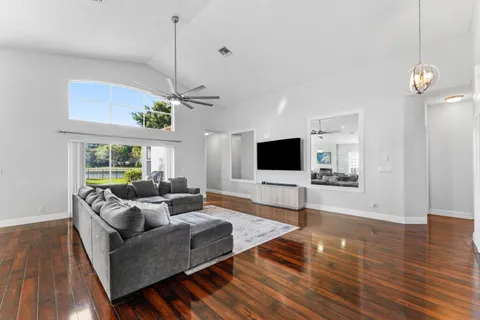 a living room with furniture a flat screen tv and a large window