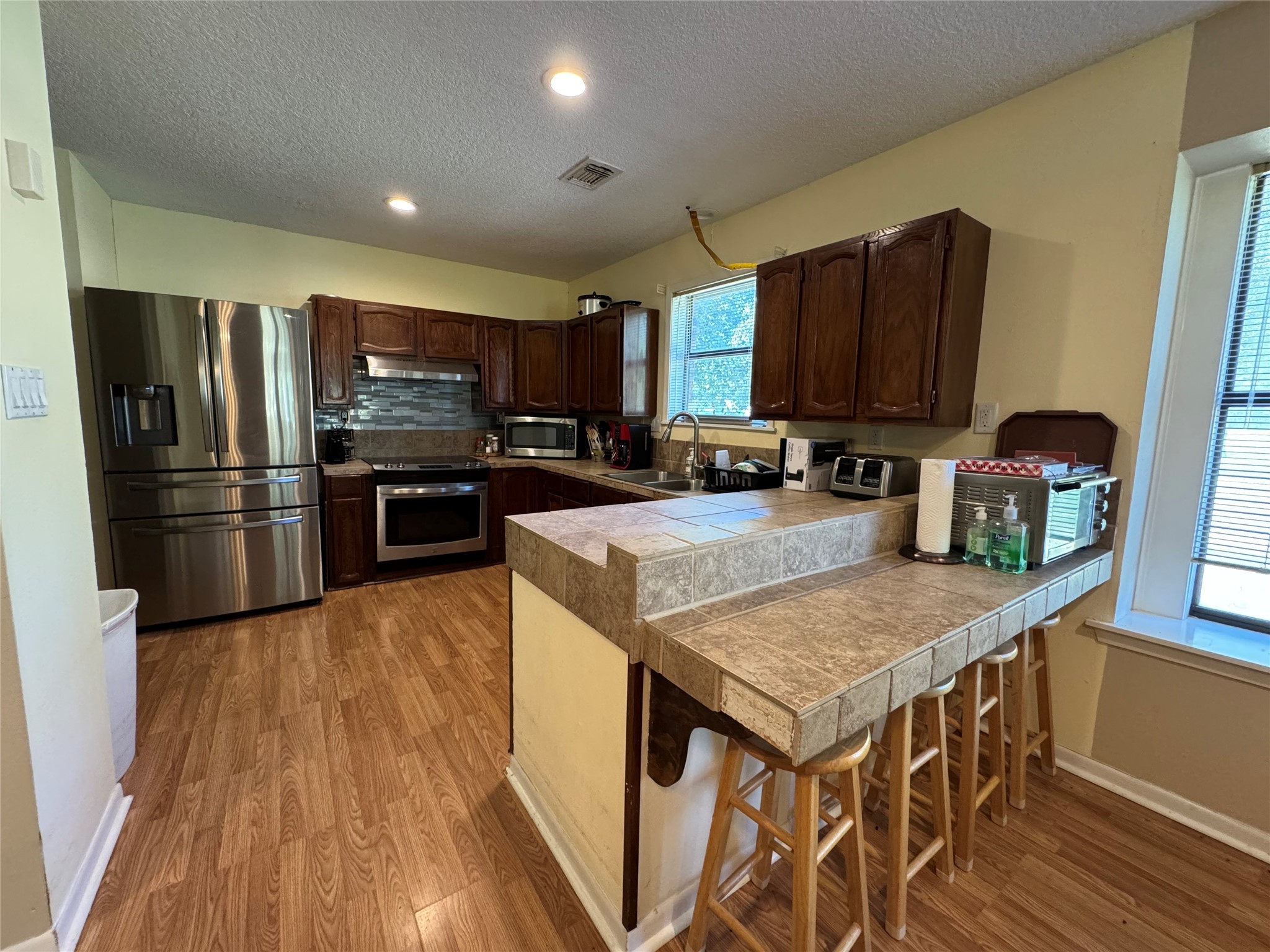 150 Schooner Drive Trinity, TX 75862 - Photo 17 of 49 a kitchen with a refrigerator a stove top oven a sink dishwasher and wooden floor