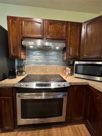 a kitchen with wooden cabinets and a stove top oven