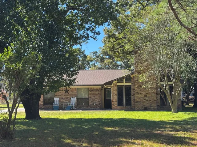 a front view of a house with a yard and trees