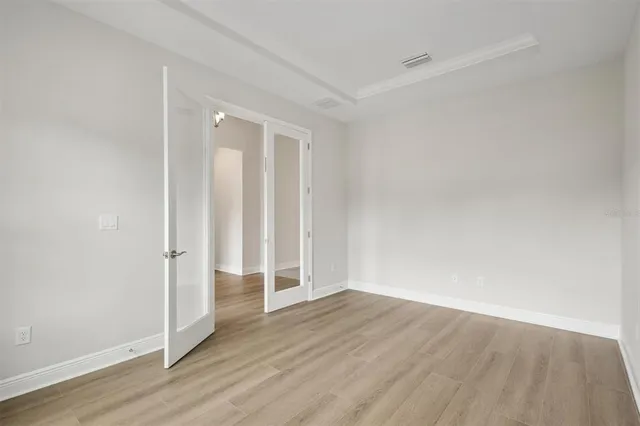 an empty room with wooden floor and entrance
