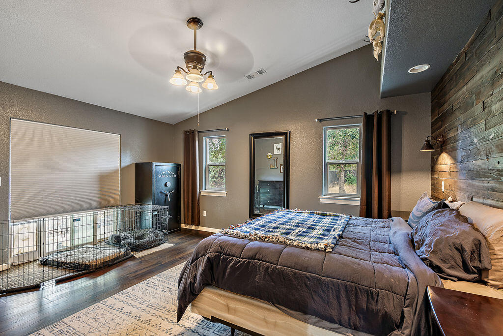 167 Rippling Way Merlin, OR 97532 - Photo 22 of 39 a bedroom with a large bed and a chandelier