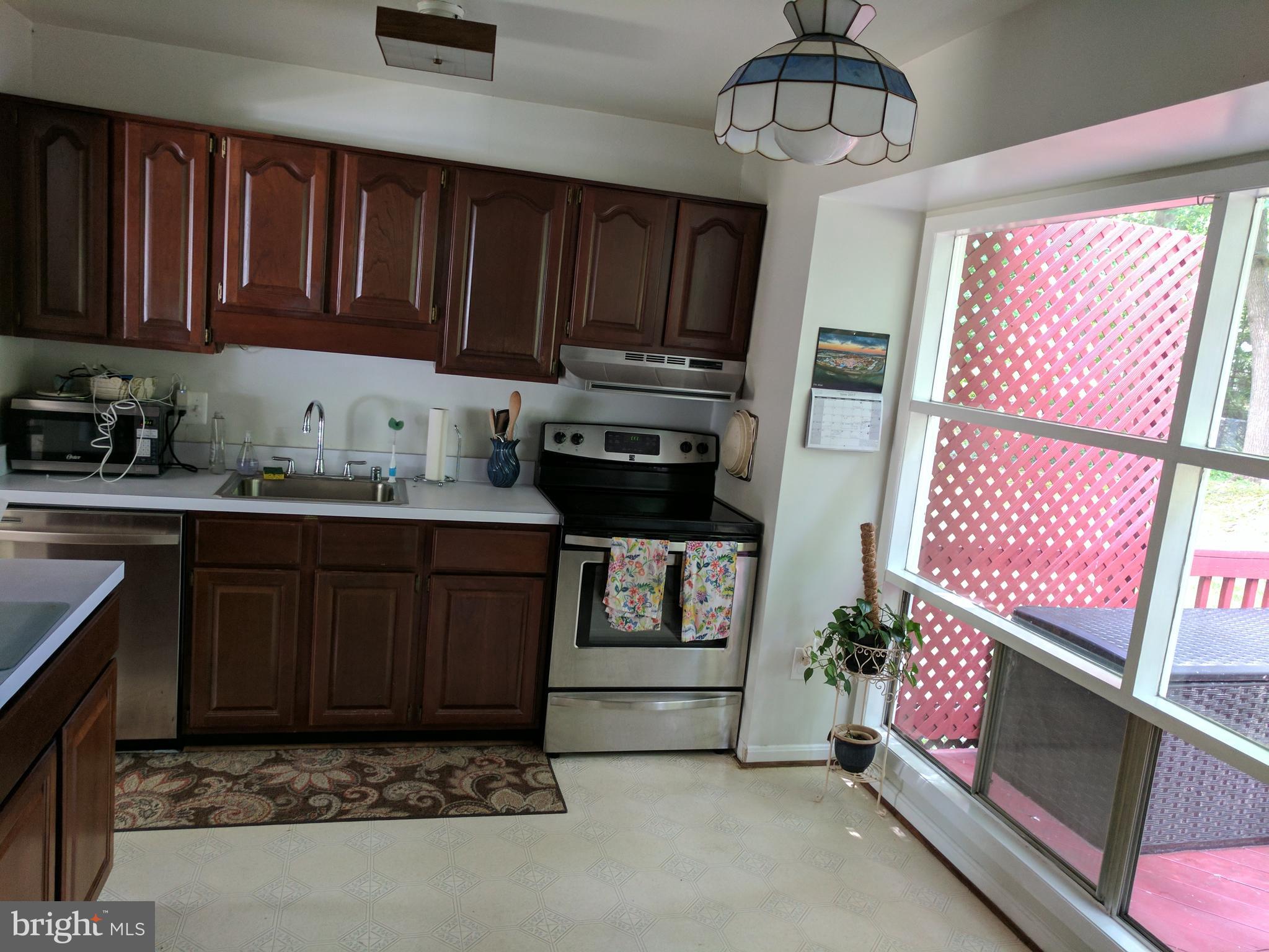 8207 Old Oaks Drive Springfield, VA 22152 - Photo 6 of 21 a kitchen with kitchen island granite countertop a stove top oven a sink and dishwasher