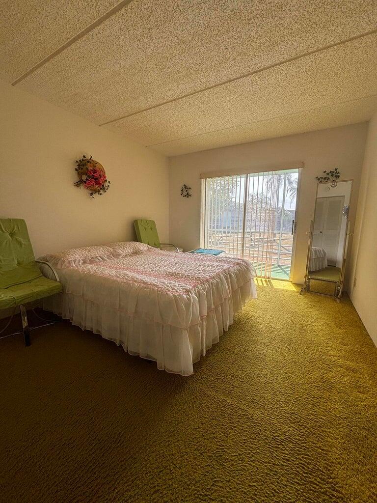 3400 Springdale Boulevard, Unit 217 Palm Springs, FL 33461 - Photo 5 of 15 a bedroom with a bed and wooden floor