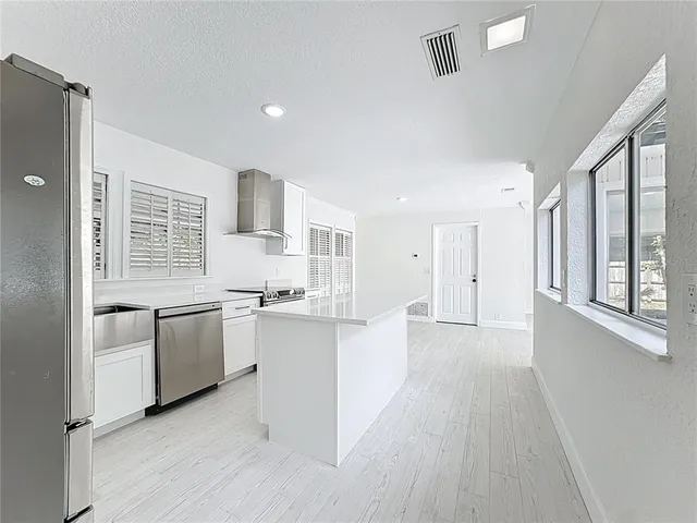 a kitchen with stainless steel appliances sink stove microwave and cabinets