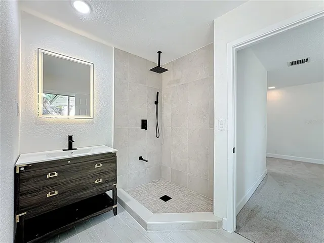 a bathroom with a granite countertop toilet a sink and a mirror
