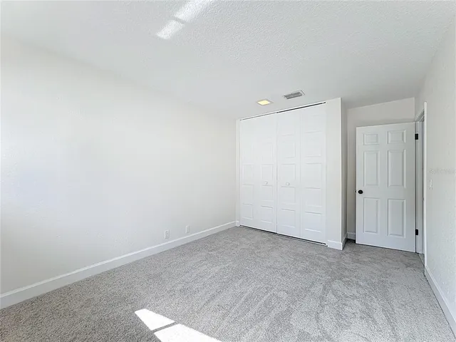 an empty room with windows and closet