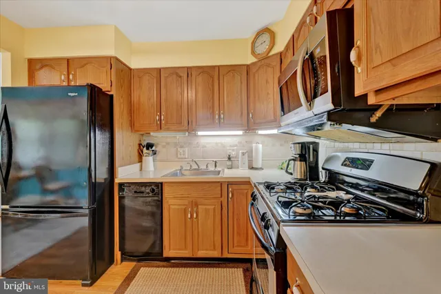 a kitchen with stainless steel appliances a stove a sink and a refrigerator