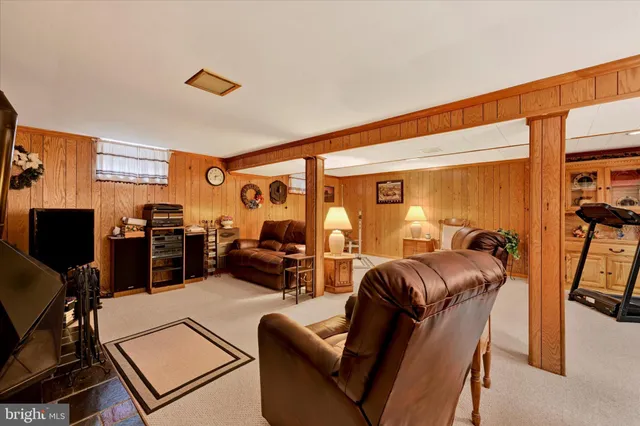 a living room with furniture a flat screen tv and a window