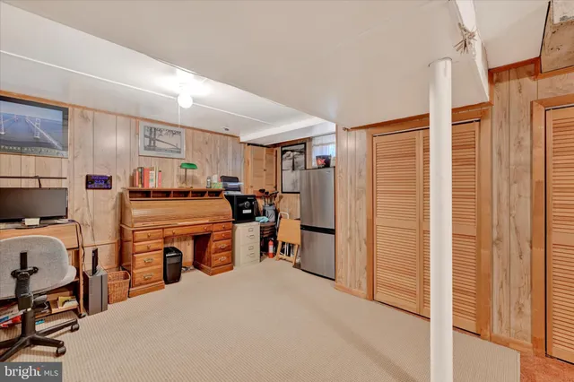 a room with furniture a flat screen tv and a refrigerator