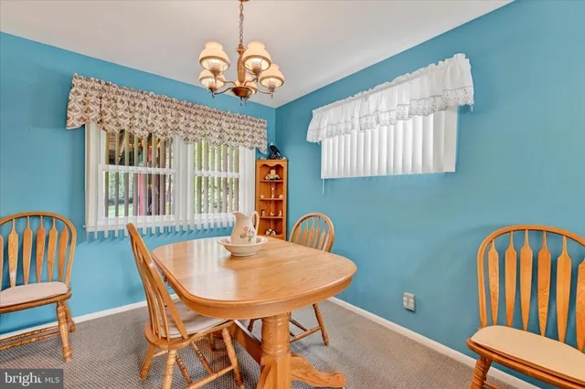 a view of a dining room with furniture wooden floor and a chandelier