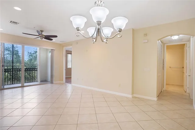 a view of a livingroom with a chandelier fan and windows