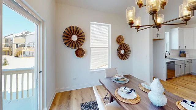 a dining room with kitchen island stainless steel appliances furniture and wooden floor