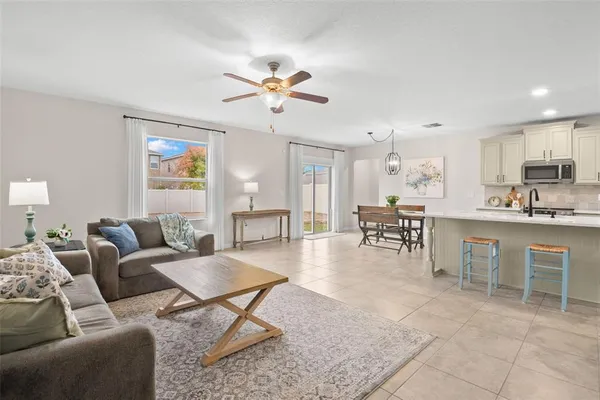a living room with furniture a dining table and kitchen view