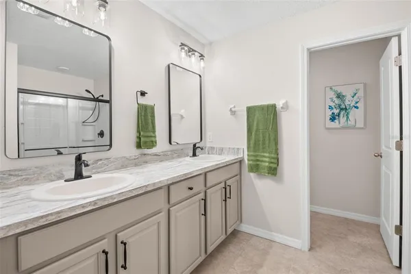 a bathroom with a double vanity sink and a mirror