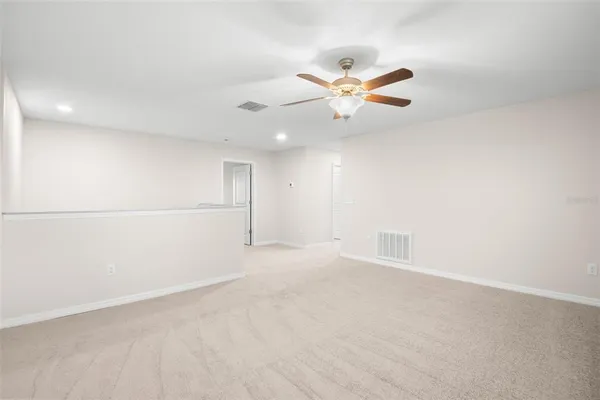 an empty room with a window and a ceiling fan