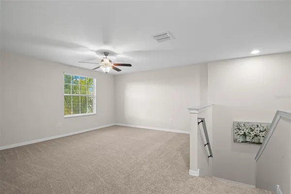 a view of a livingroom with a ceiling fan and window