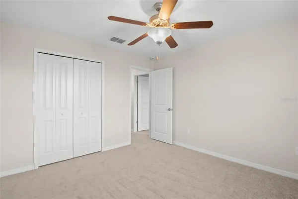 an empty room with chandelier fan