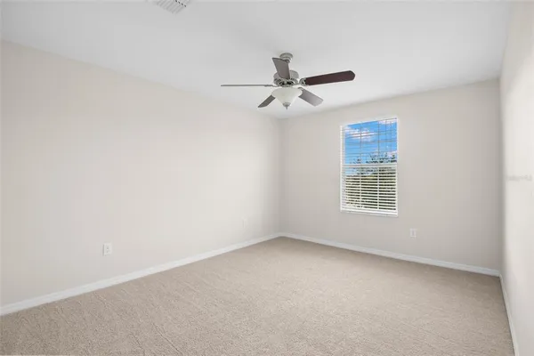 an empty room with a window and a fan