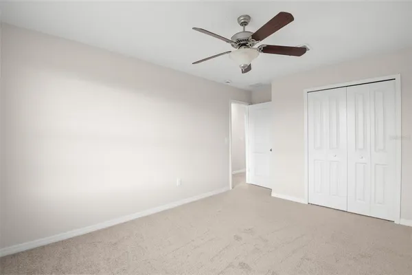 an empty room with a ceiling fan and a window