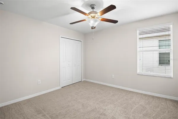 an empty room with a window and a fan